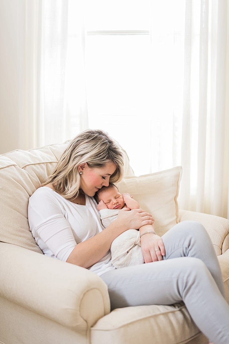 raleigh, nc mom kissing newborn baby girl in white chair photo
