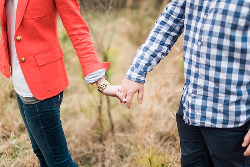 raleigh nc couple holding hands in a field photo