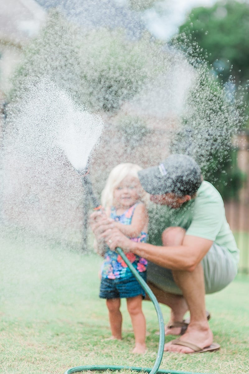 toddler playing with the water hose photo