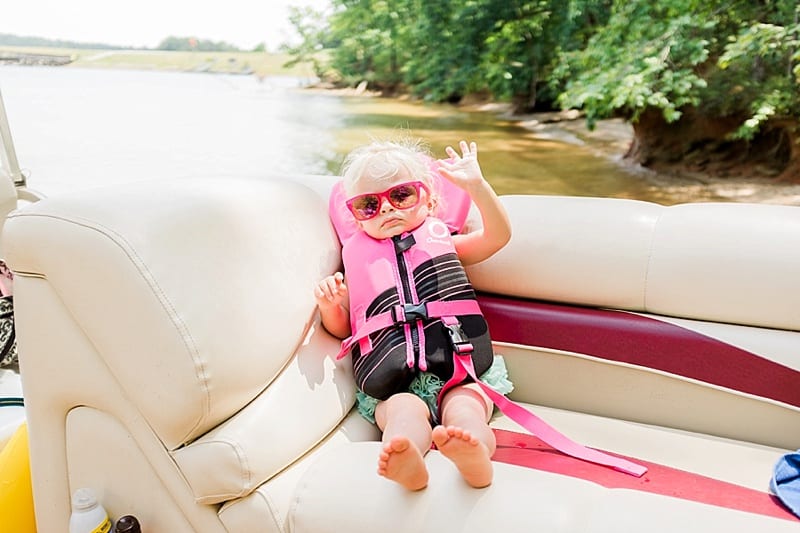 toddler in life jacket and pink sunglasses photo