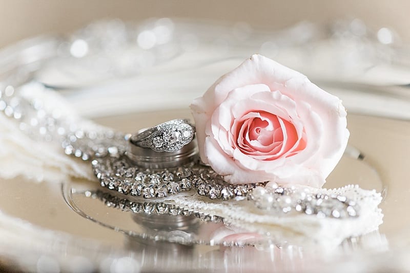 wedding rings on a silver platter with a rose photo