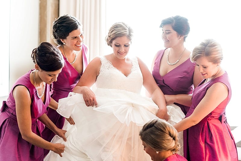 proximity hotel bridesmaids helping bride get dressed photo
