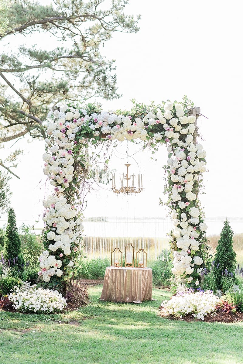 huge arbor covered in florals for wedding ceremony photo