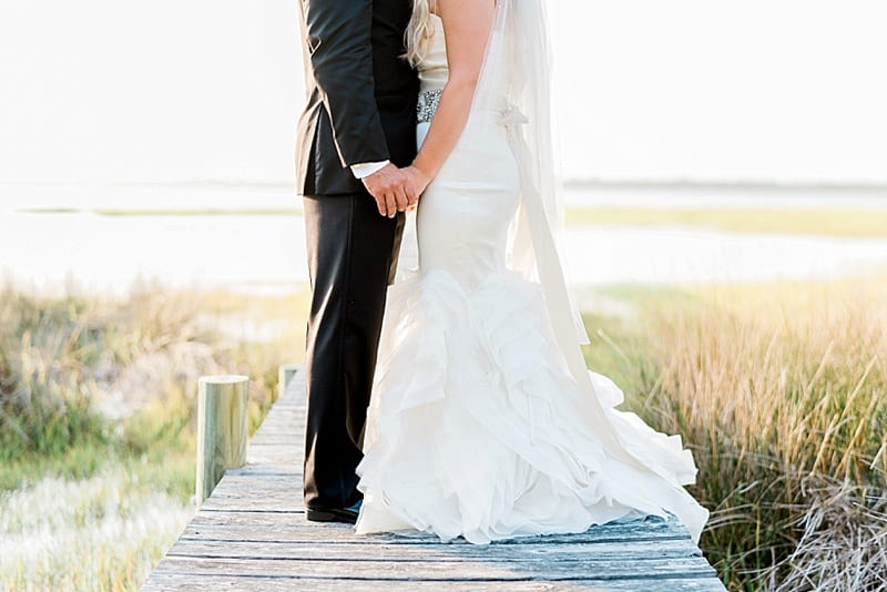 emerald isle bride and groom holding hands photo
