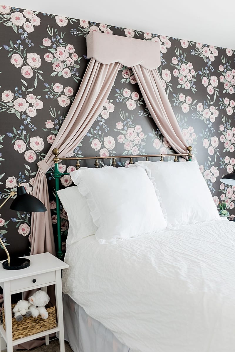 pink velvet valence and draping on floral wall paper behind a vintage bed frame photo