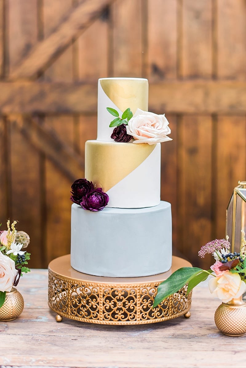 styled shoot gold and white wedding cake with flowers photo