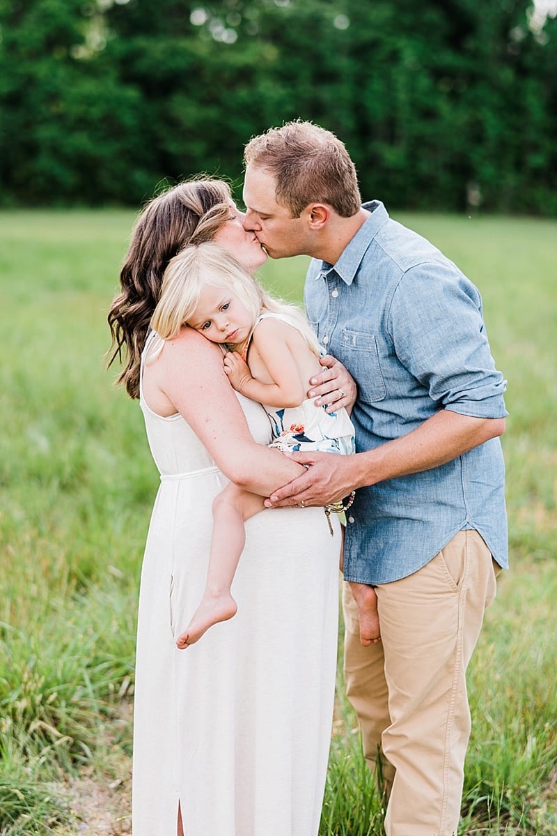 raleigh mother and father kissing with toddler photo