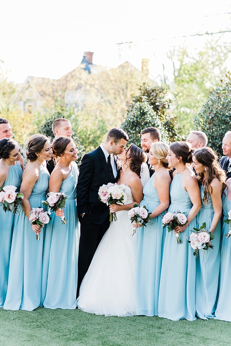 merrimon wynne bride and groom kissing with bridal party photo