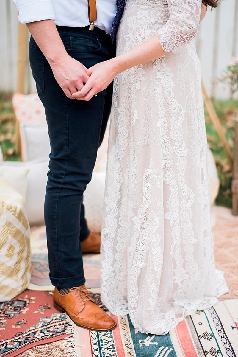bride in lace gown hold hands with groom photo