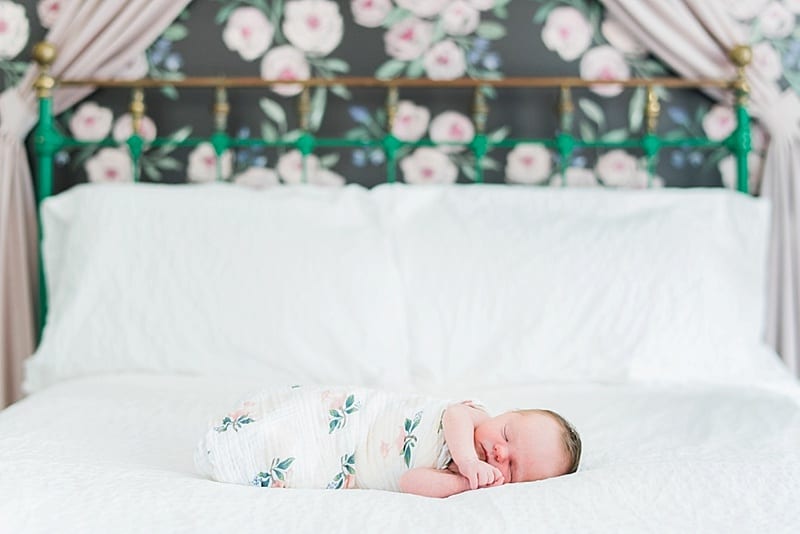 newborn portrait in front of floral wall paper photo