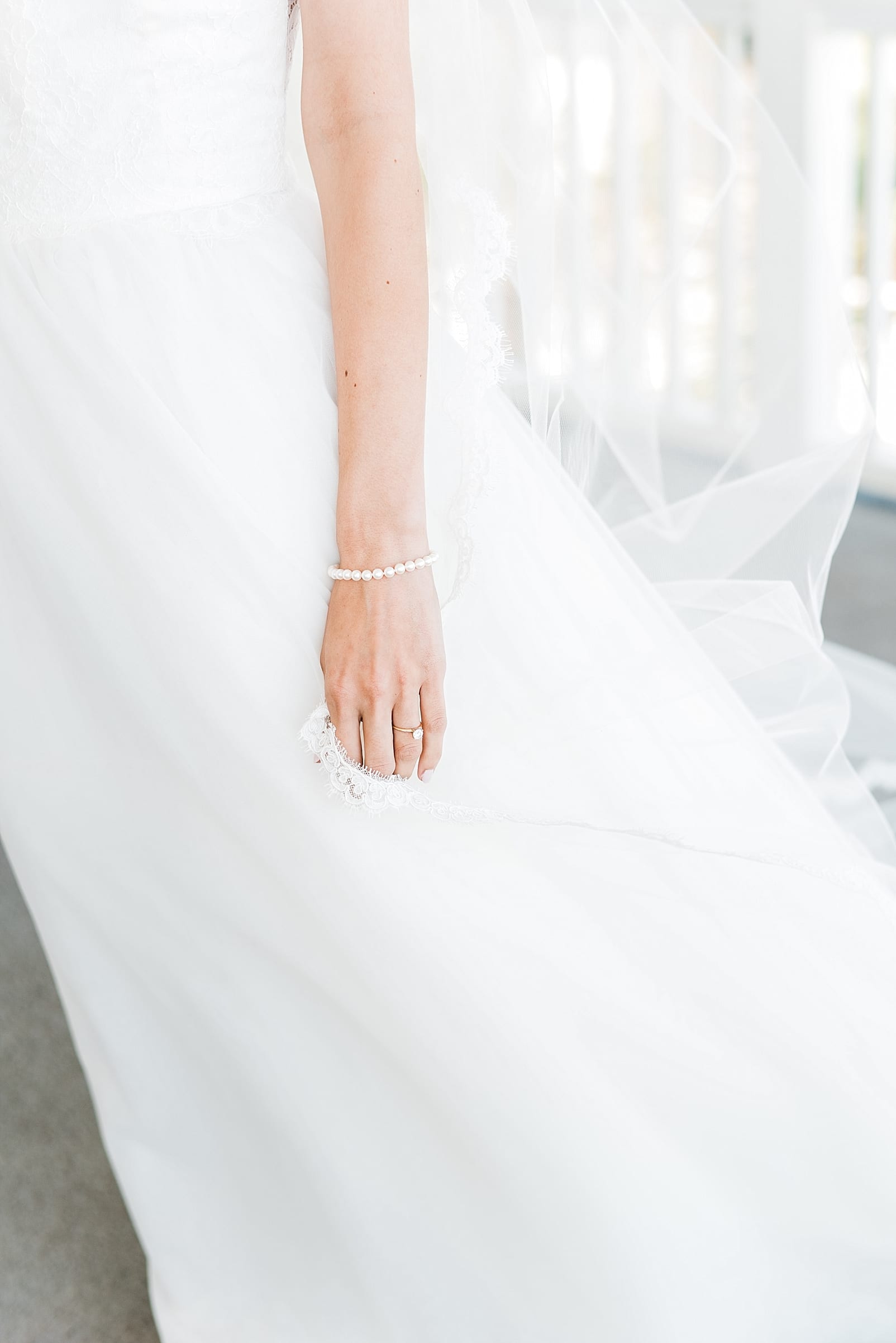 bride in wedding dress pearl bracelet windblown photo