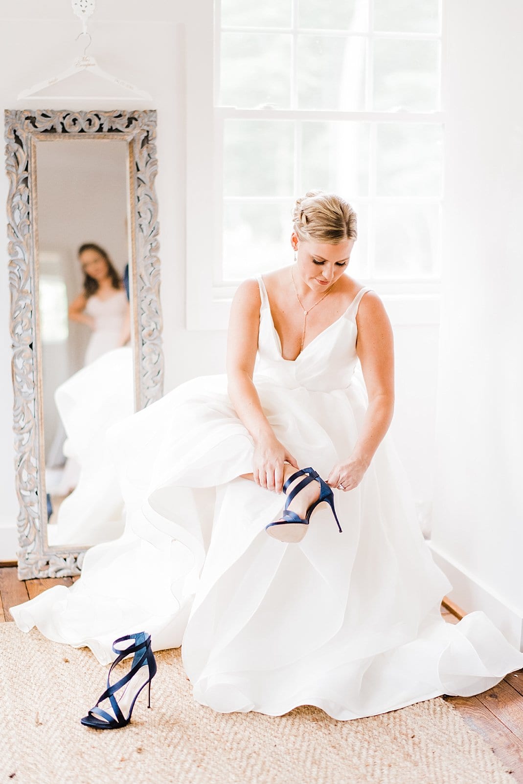 barn at chapel hill bride putting on navy shoes photo