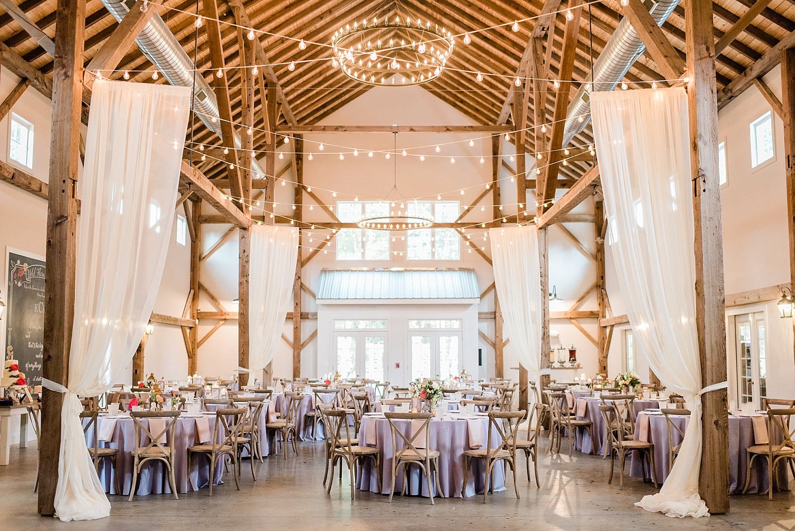 barn at chapel hill wedding reception with hanging lights and exposed beams photo
