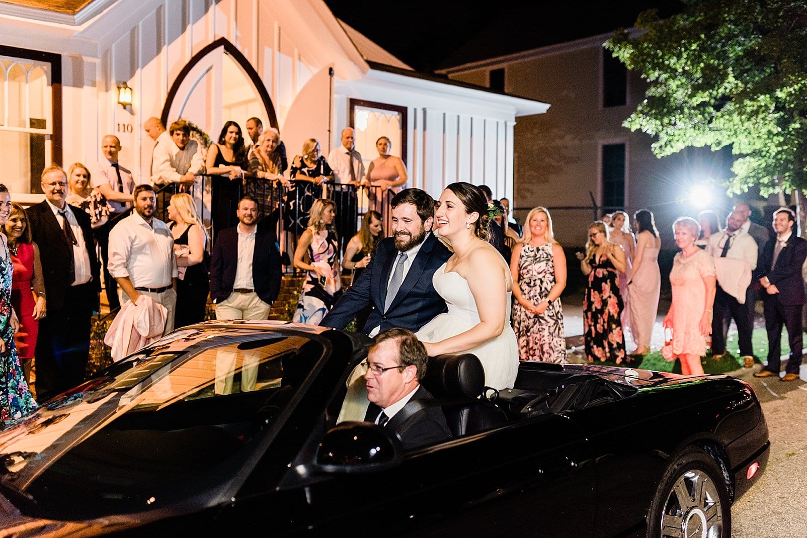 downtown raleigh wedding bride and groom riding away in black convertible photo