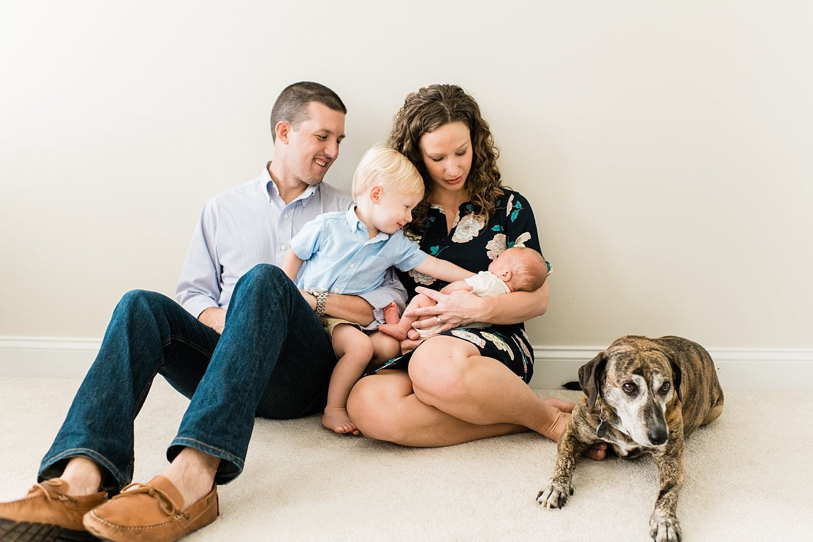 raleigh family snuggled on the floor with big sibling and dog photo