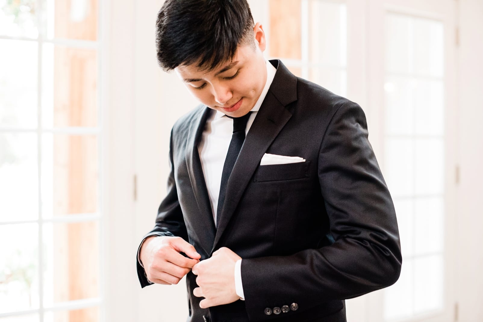 Barn of Chapel Hill groom getting dress in brooks brothers suit photo