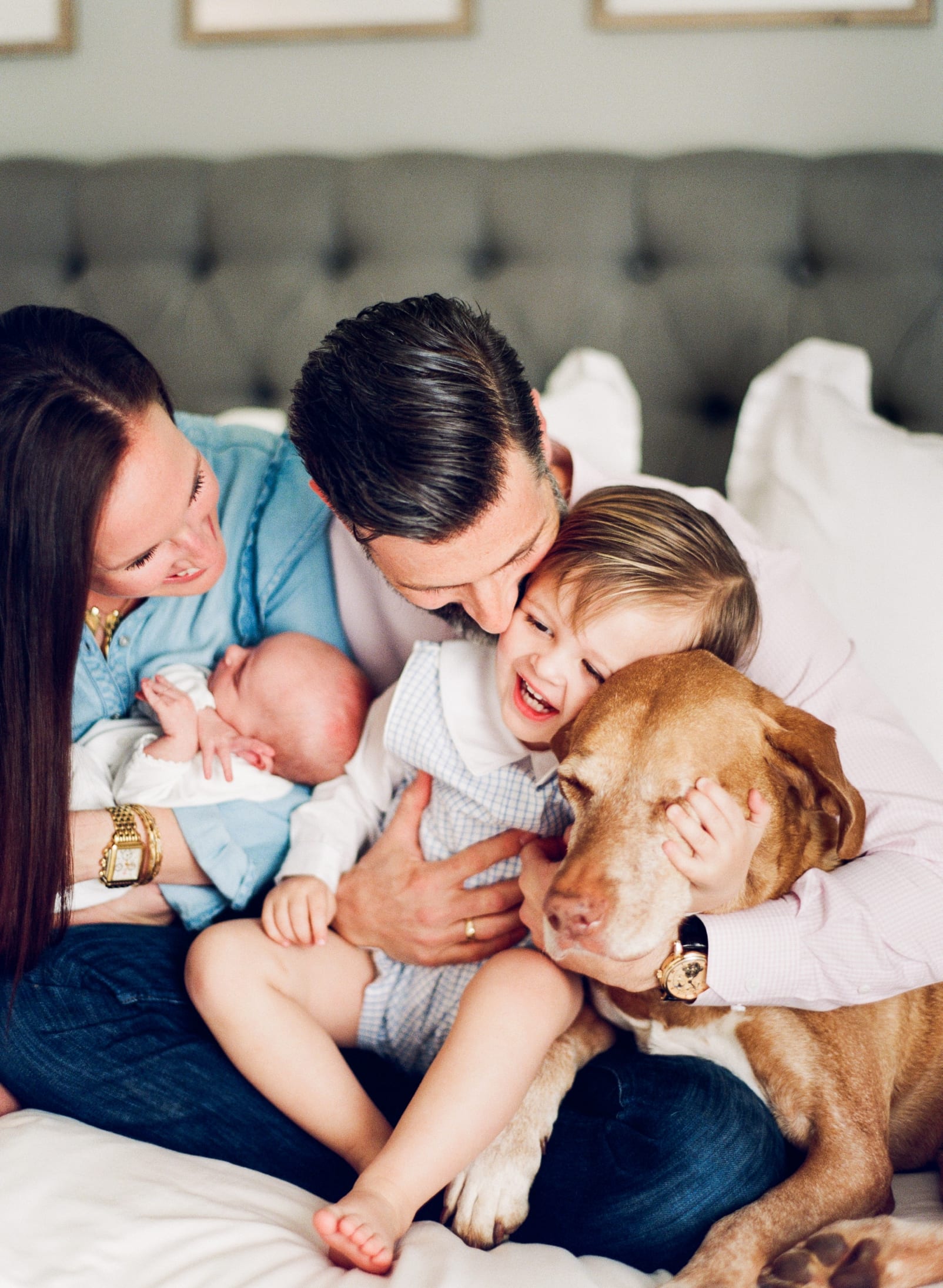 Apex, NC whole family snuggled on bed with dog for newborn session photo