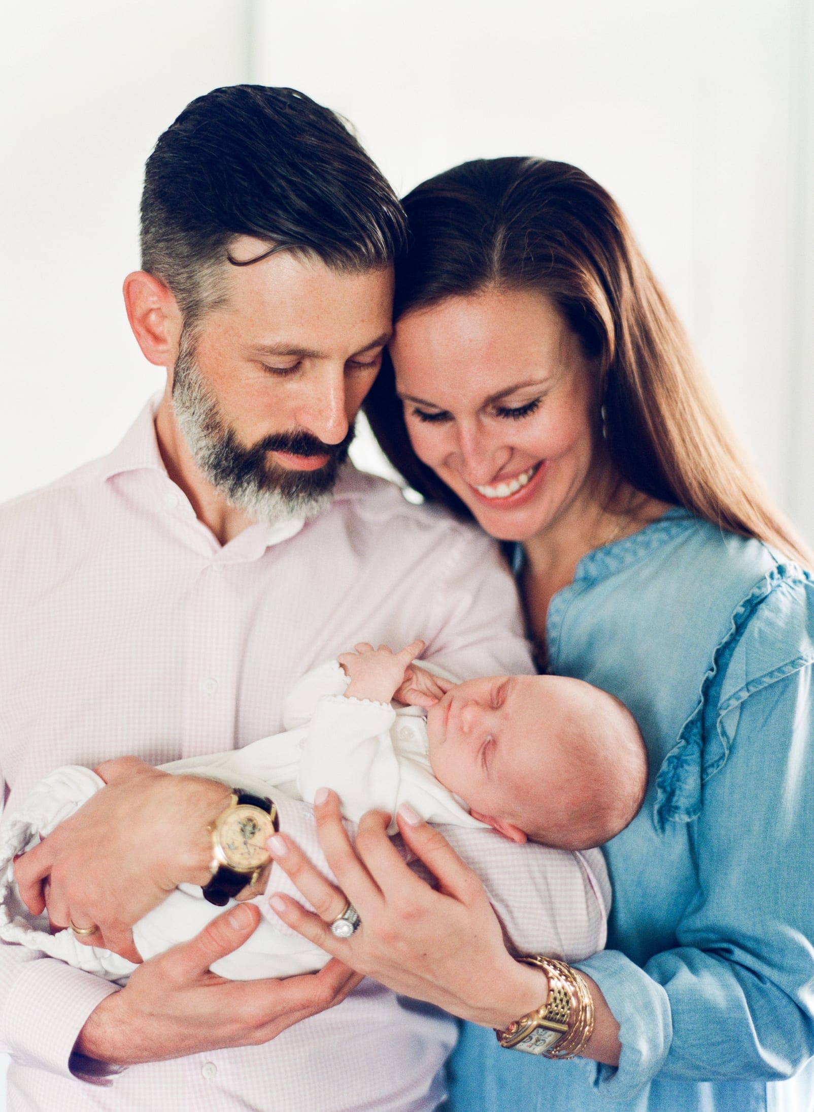 Apex mother and father holding newborn baby girl photo