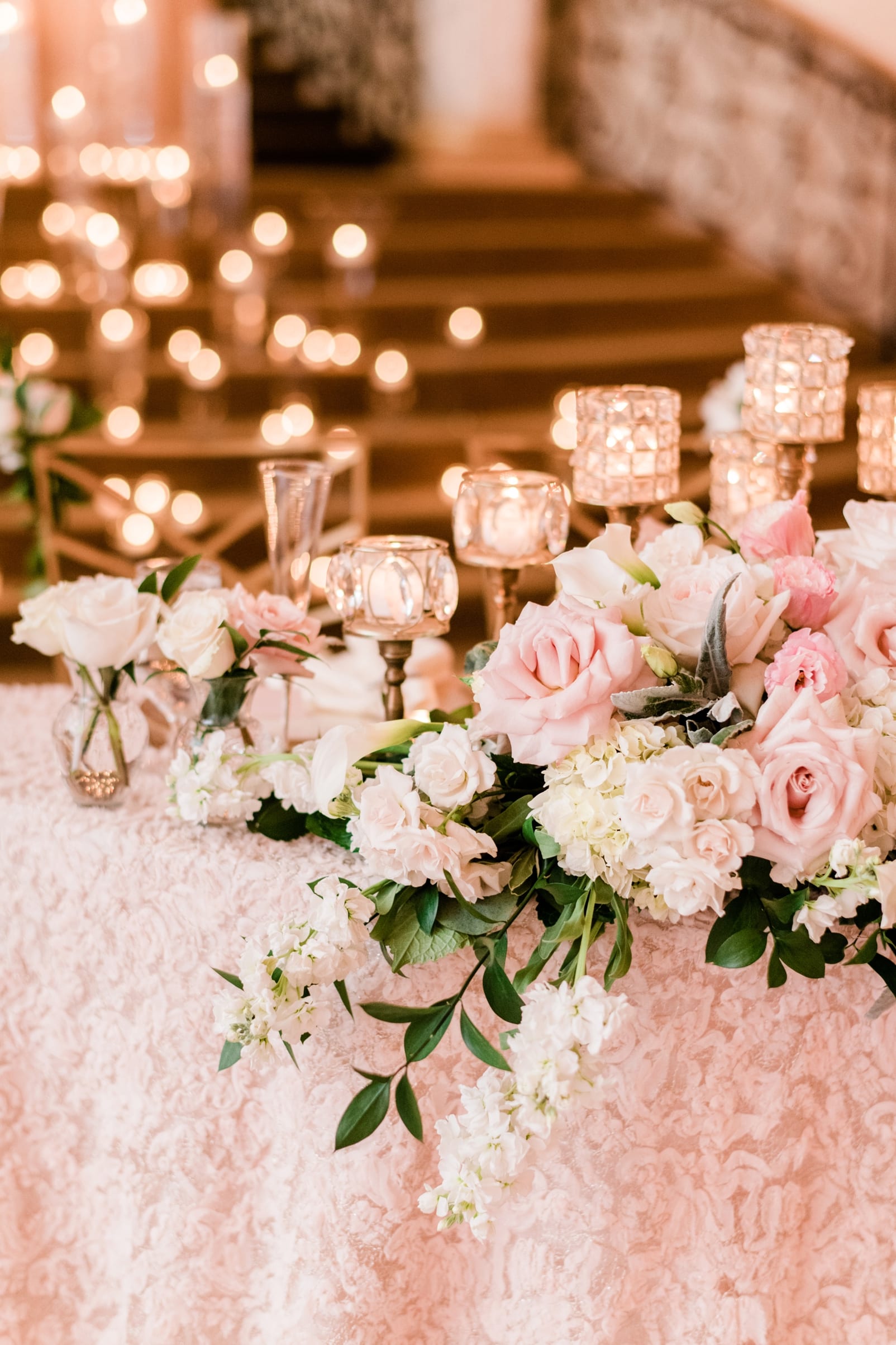 Expressions of Love Florist wedding reception table with flowers cascading across it with candles photo