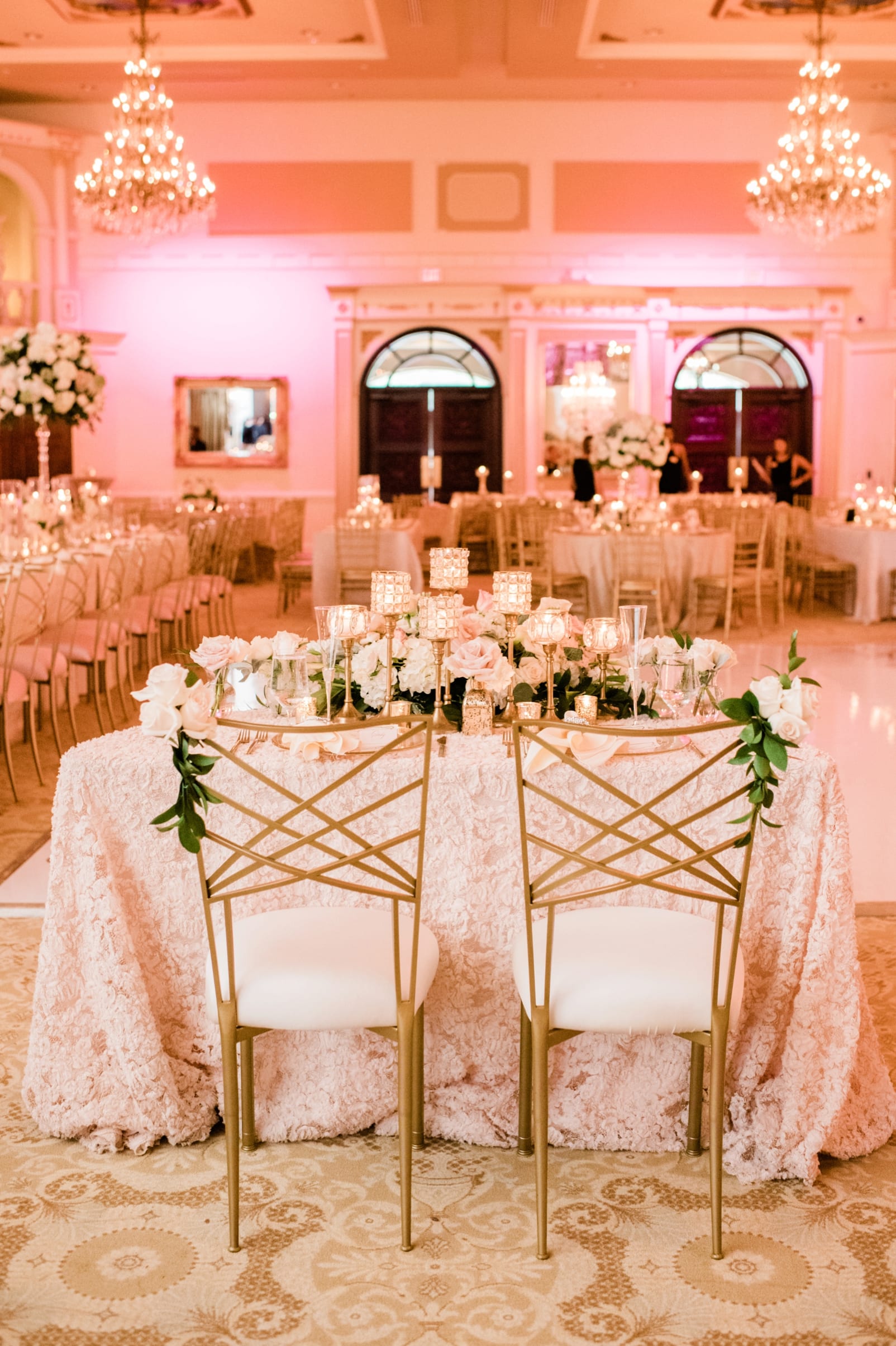 Grand Marquise Ballroom head table with gold plated chairs with large floral installation with candles photo