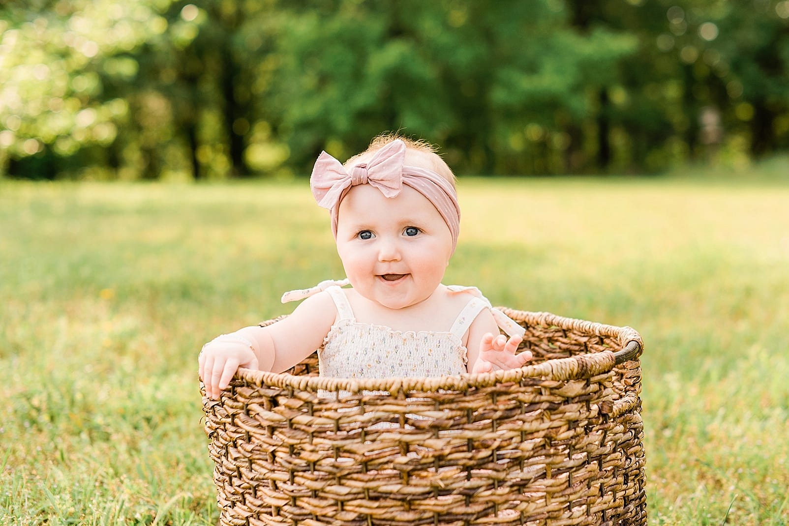 Raleigh nine month old sitting in a big wicker basket photo