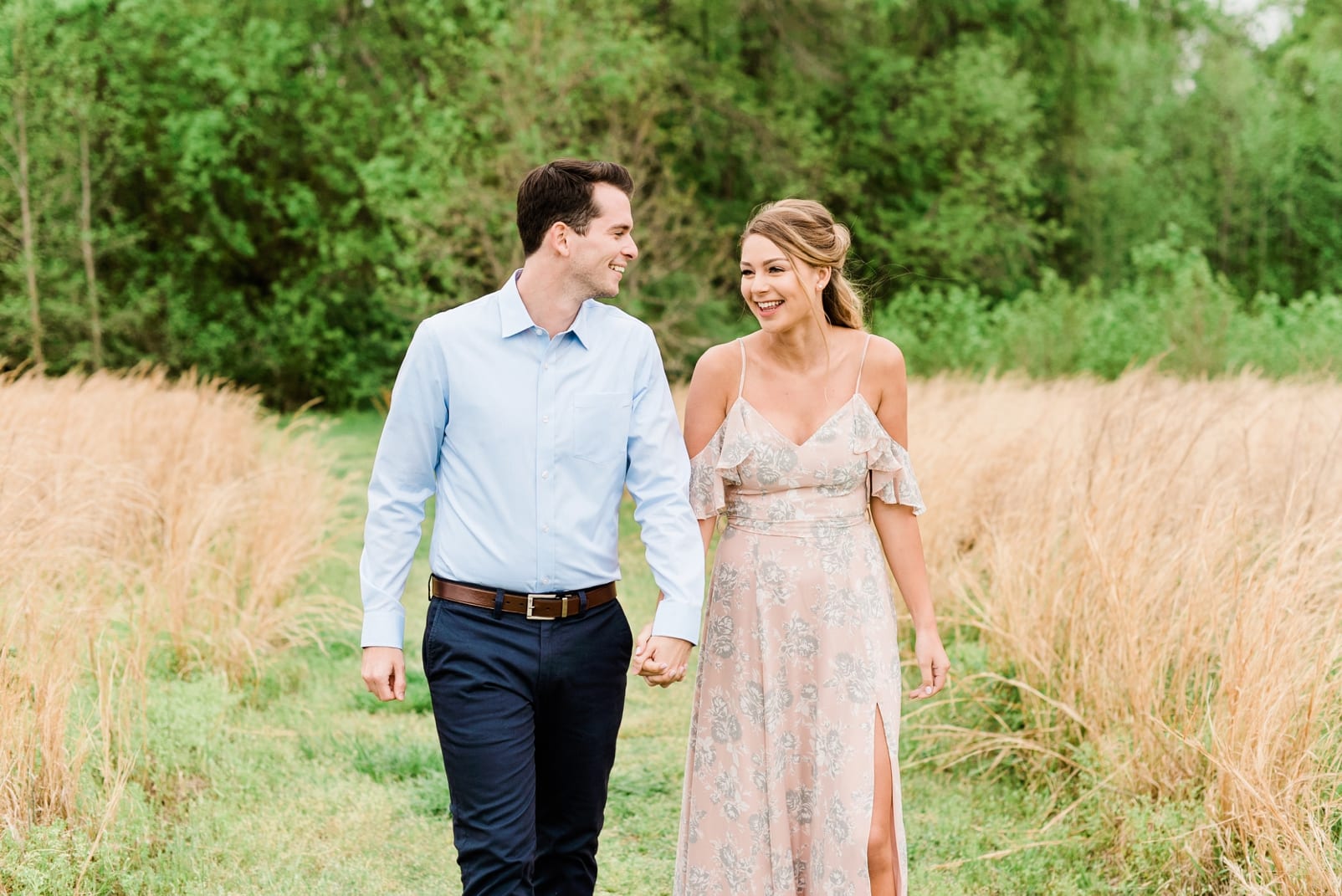 Wake Forest spring session couple holding hands walking down a grass path photo