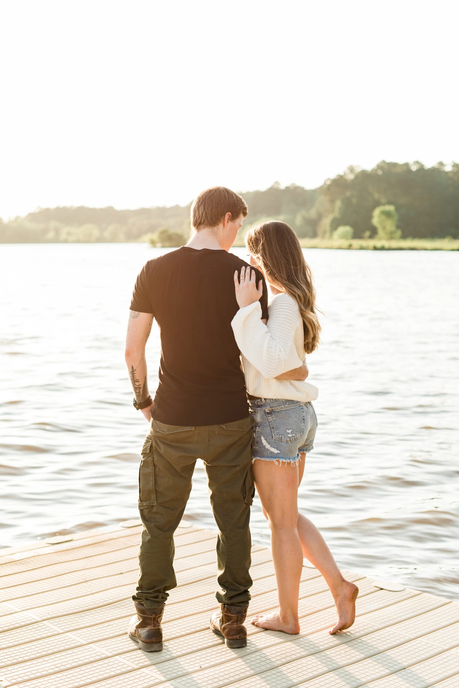 Lake Crabtree engagement session with couple embracing in front of the lake photo