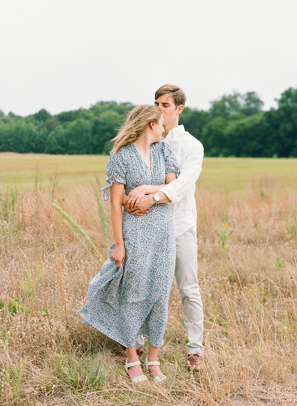 Raleigh photographer engagement session with couple embracing and looking off in the distance photo
