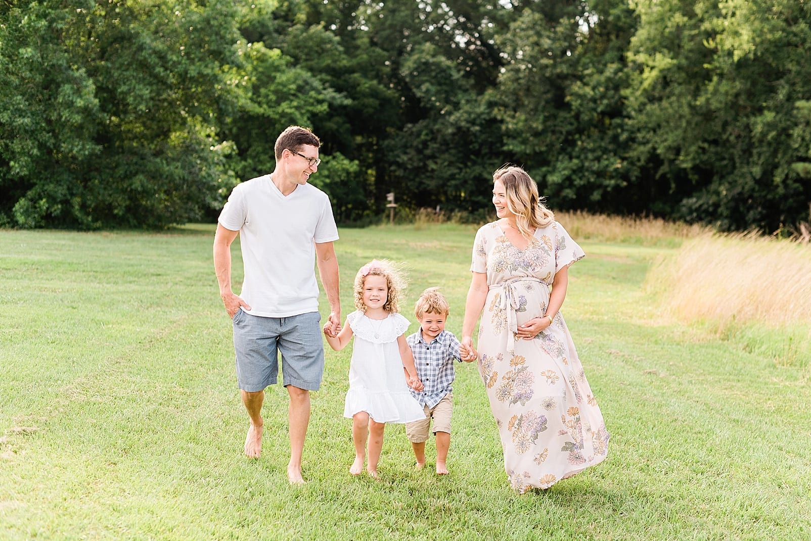 Wake Forest family of four walking together with the mother pregnant photo