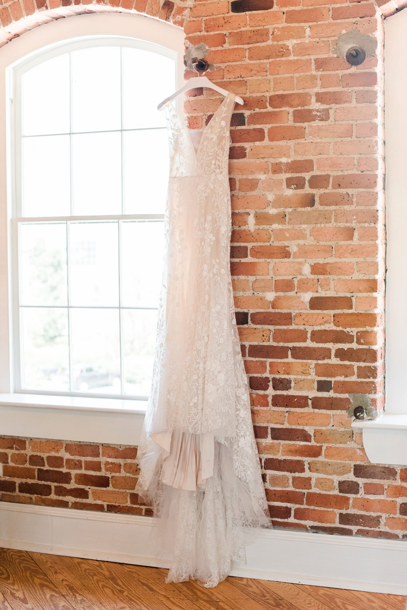 Monique Lhuillier wedding dressing from Alexia's styled on exposed red brick wall photo