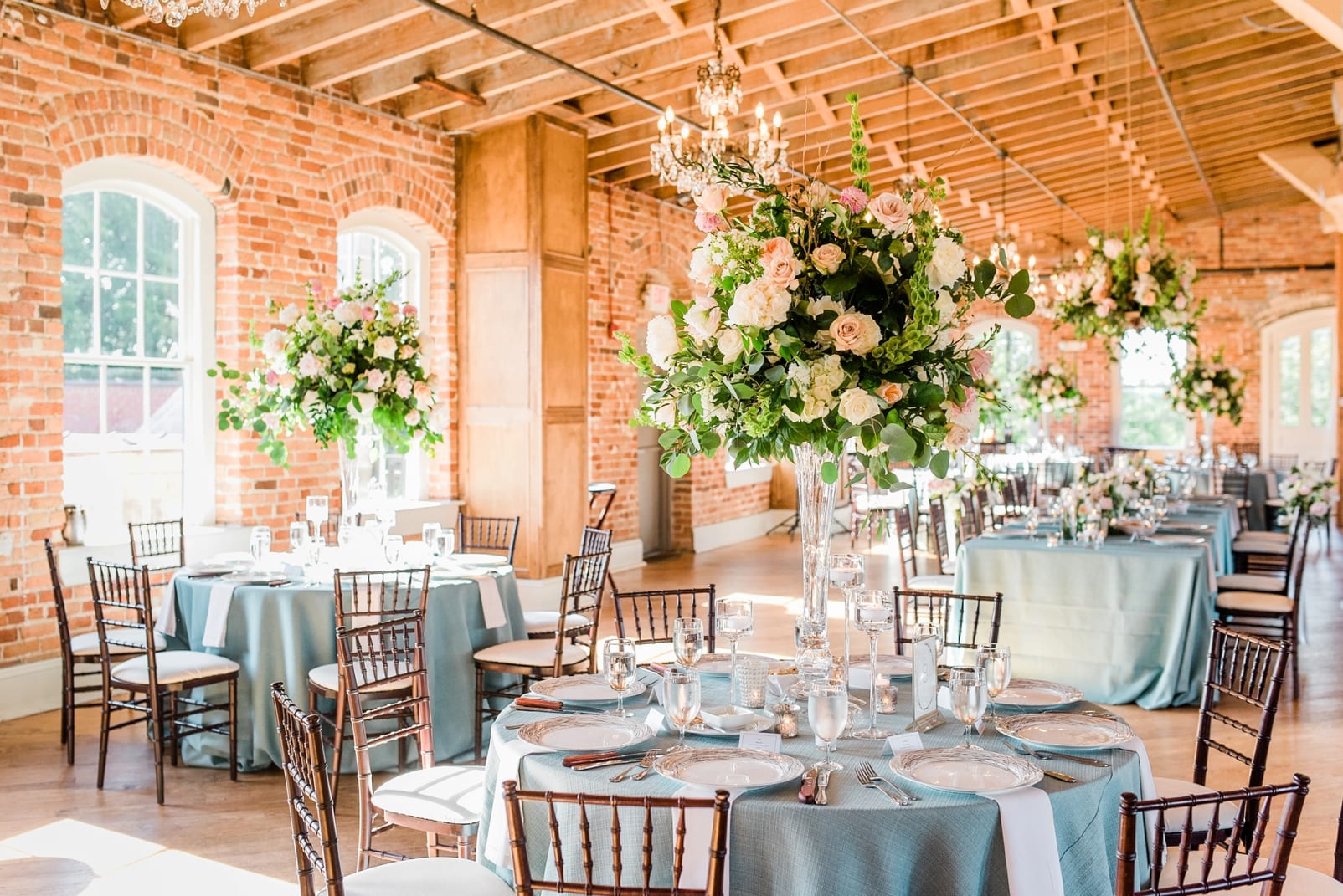 Raleigh indoor wedding reception at Melrose Knitting Mill with exposed red brick walls and light blue table clothes photo