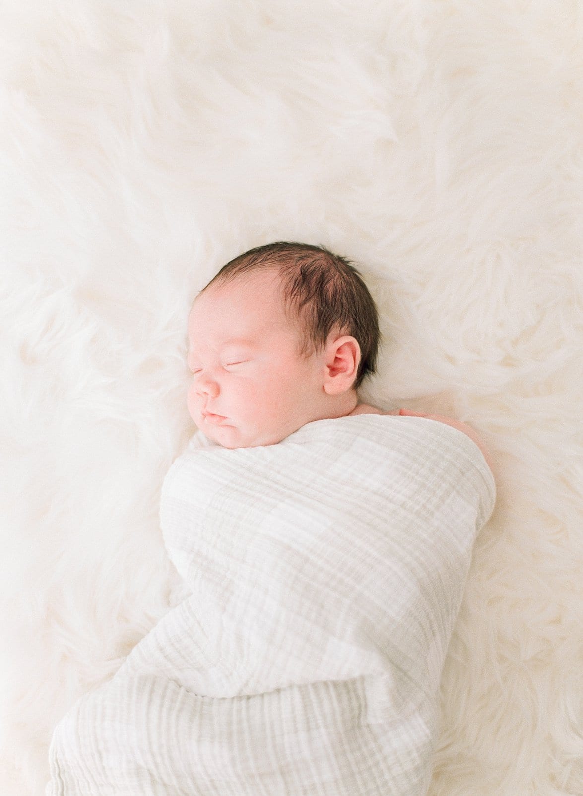 Raleigh newborn wrapped in a cream swaddle photo