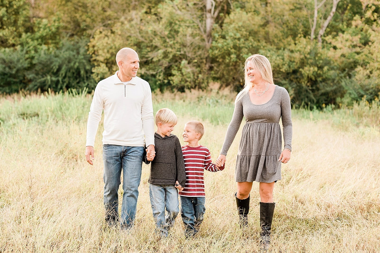 Wake forest mother and father walking and holding hands with their two young sons photo