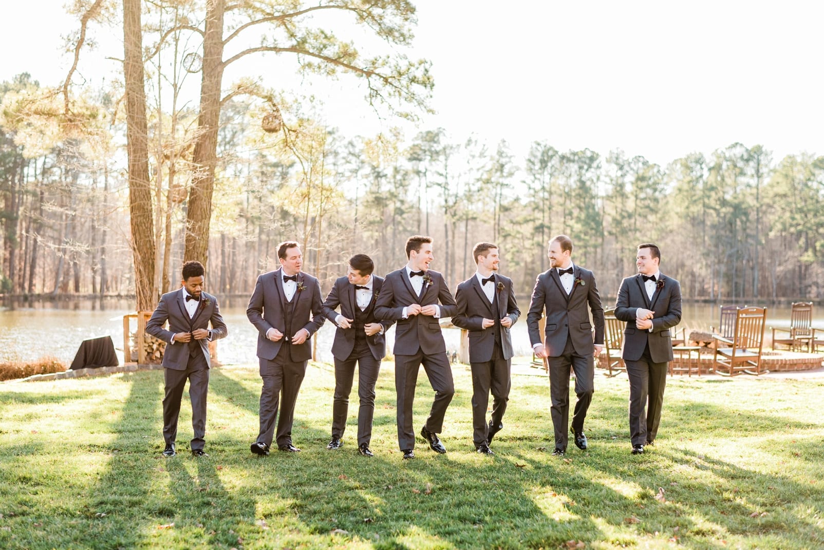 Angus barn groomsmen walking together with the groom while buttoning their jacket photo