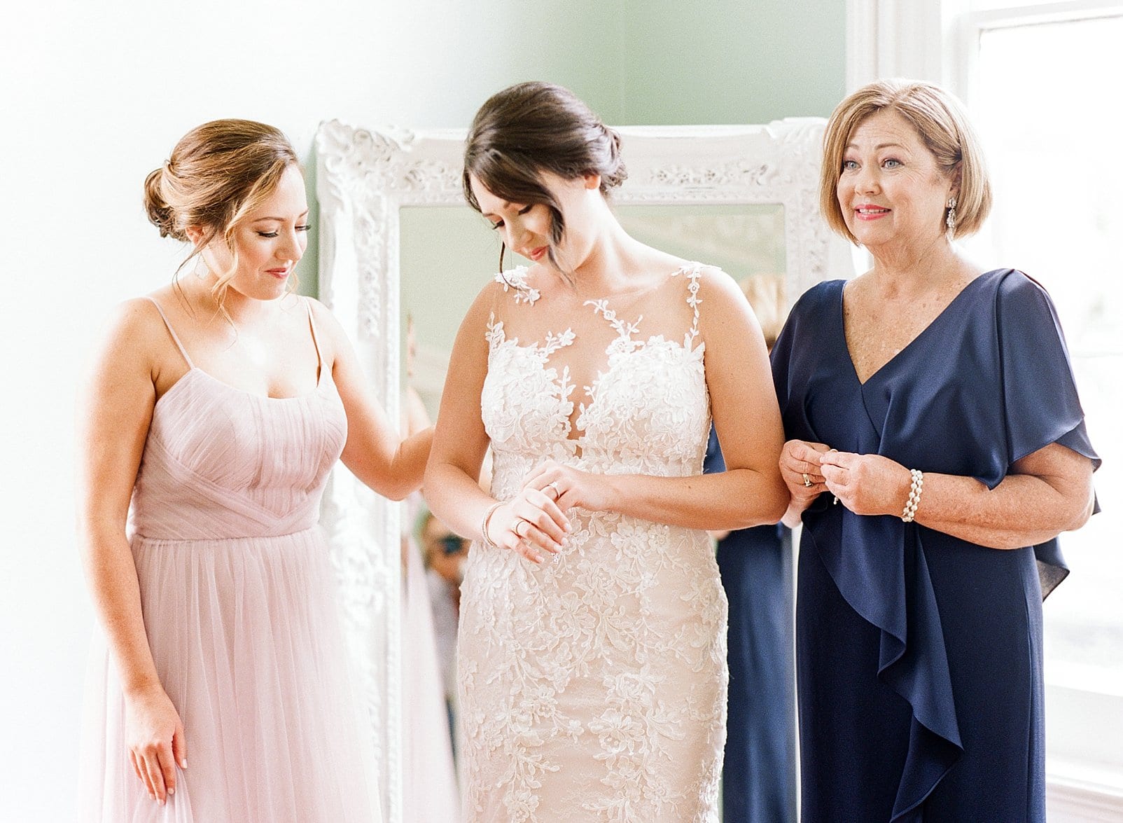 Merrimon Wynne bride standing with her maid of honor and her mother in a navy blue dress photof