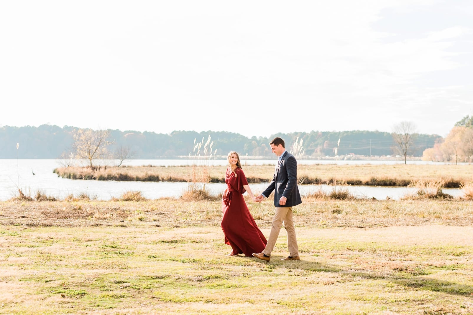 Raleigh couple walking with the fiancee walking ahead leading her finance photo