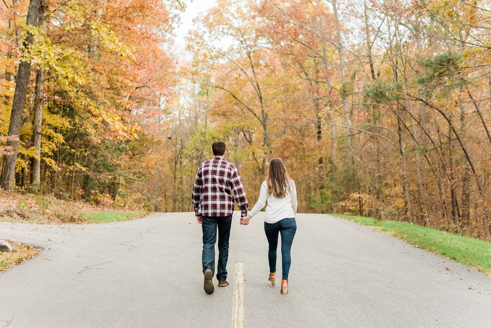 Raleigh couple walking and holding hands in the fall foliage photo