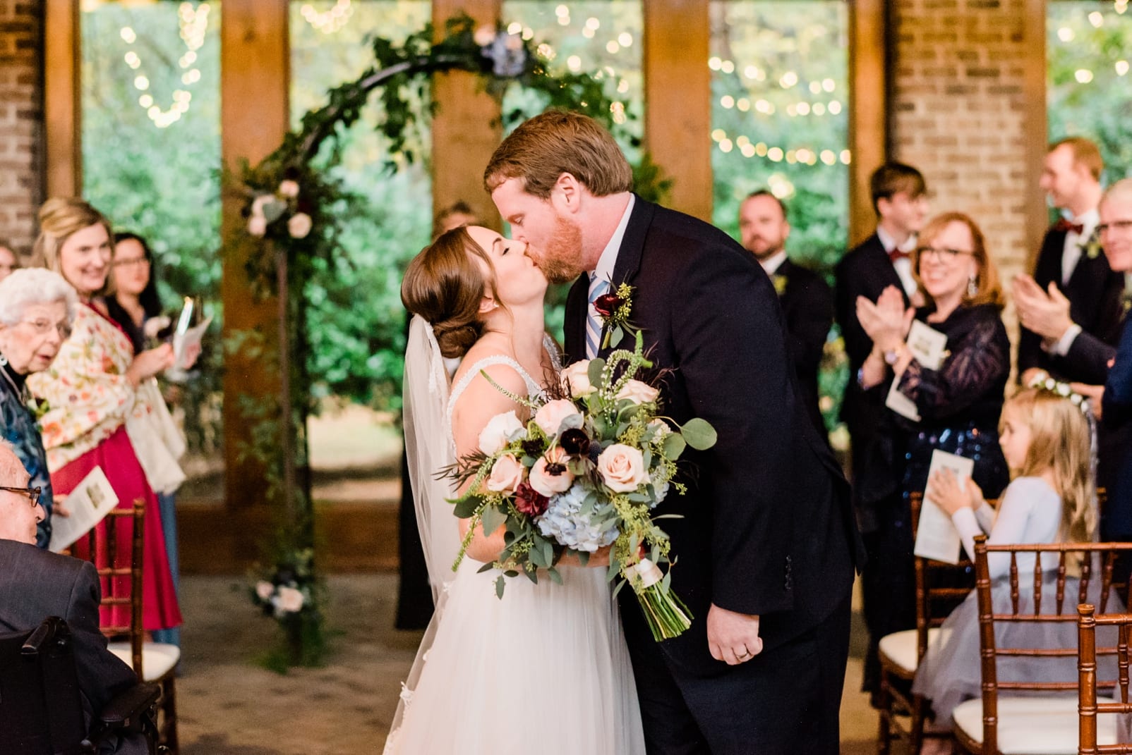 Wake Forest indoor wedding ceremony bride and groom kissing after getting married photo