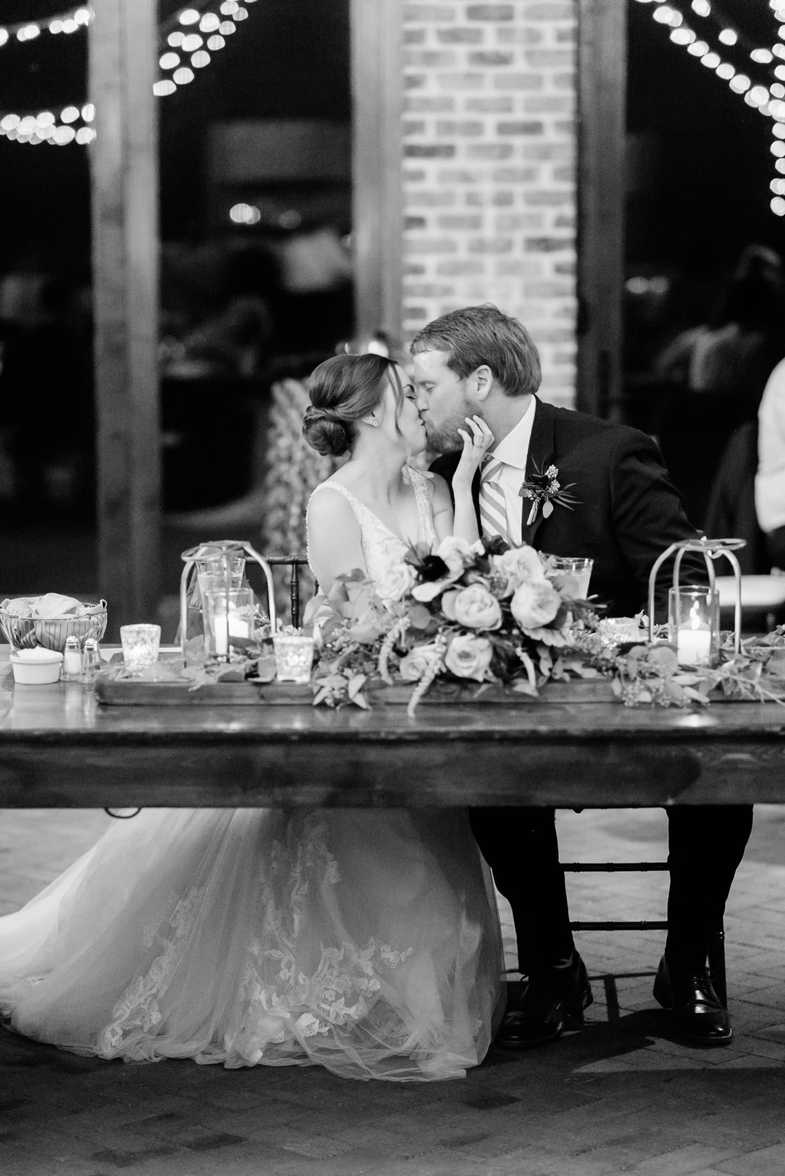 Sutherland Estate reception bride and groom kissing at the sweetheart table photo