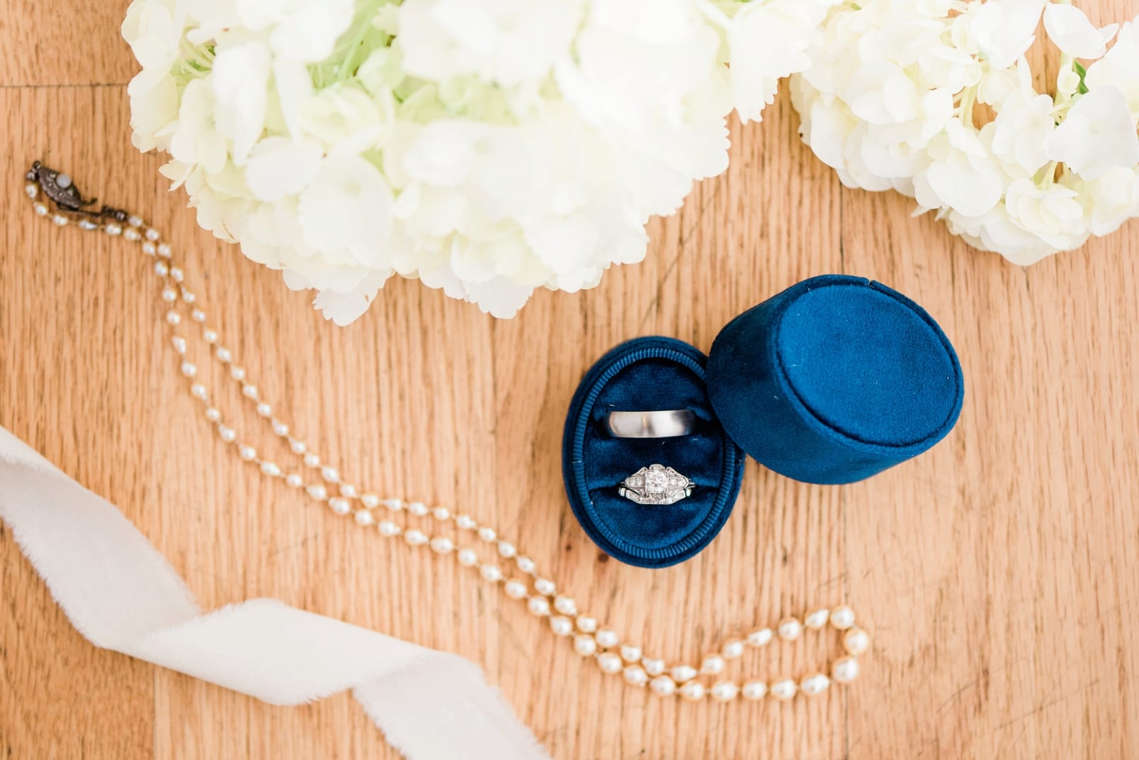 The Glass Box bridal pearls styled with a navy blue velvet ring box photo