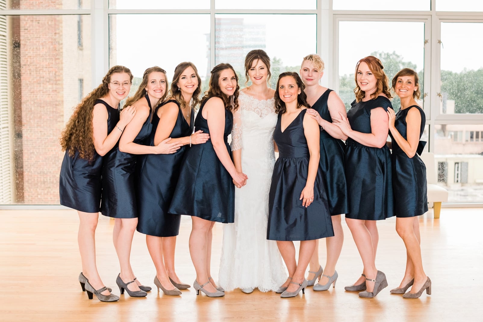 The Glass Box bride with her bridesmaids wearing short navy blue dresses photo