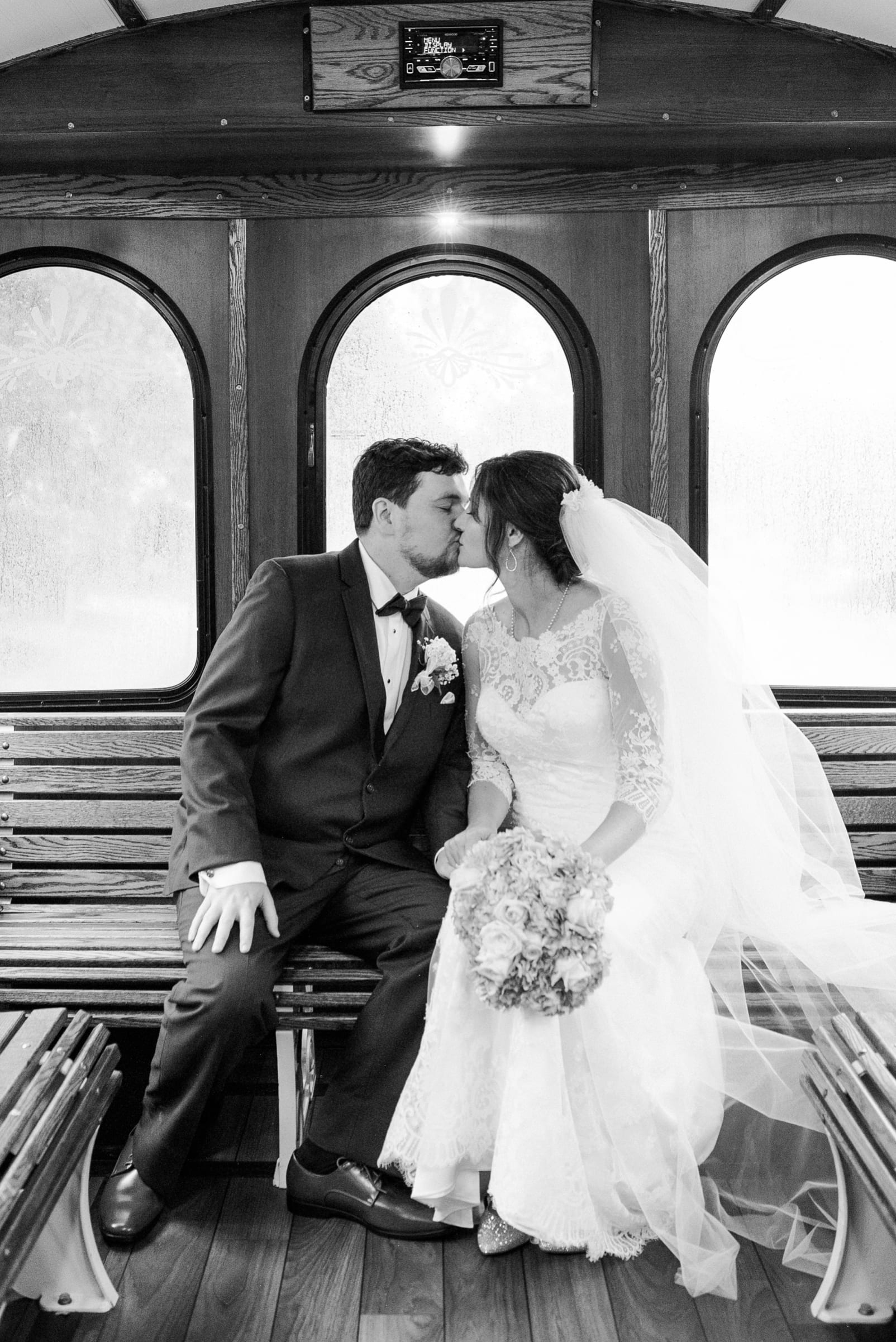 The Great Raleigh Trolley bride and groom kissing in the back of the trolley after just getting married photo