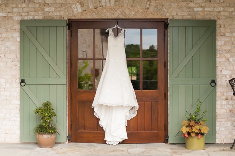 Wedding dress hanging in front of barn doors- A.J. Dunlap Photography