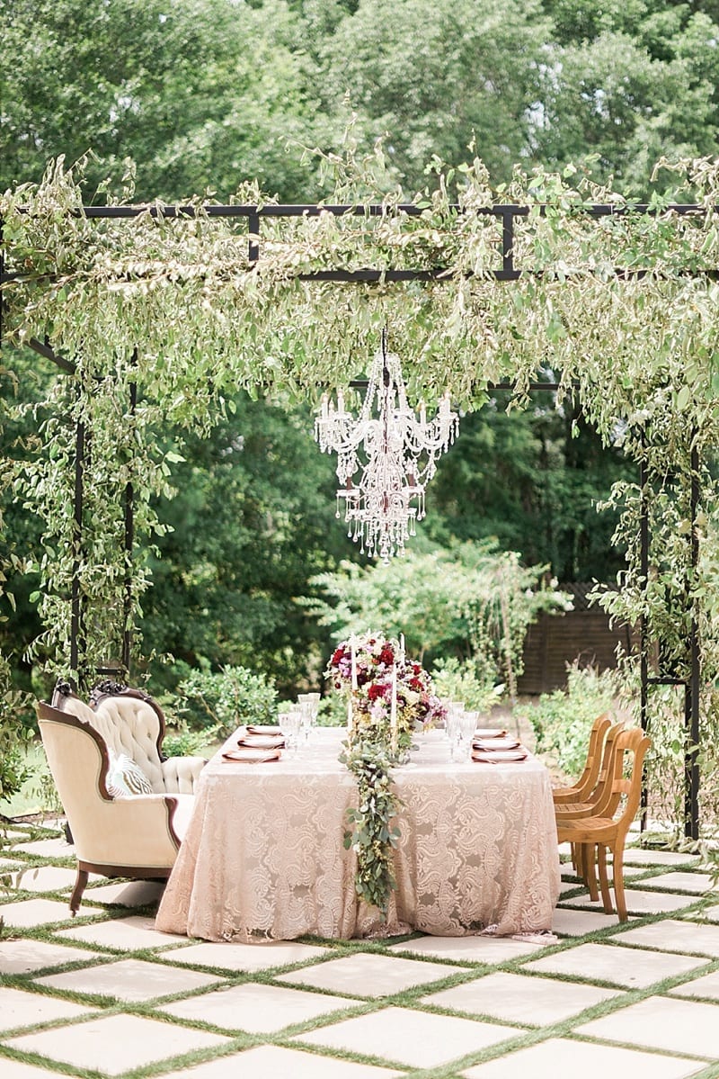 head table under arbor with chandelier