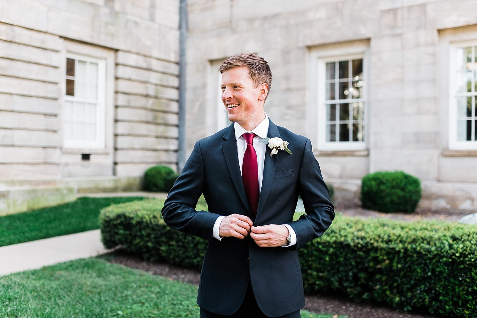 raleigh wedding photographer raleigh capitol building groom with burgundy tie photo