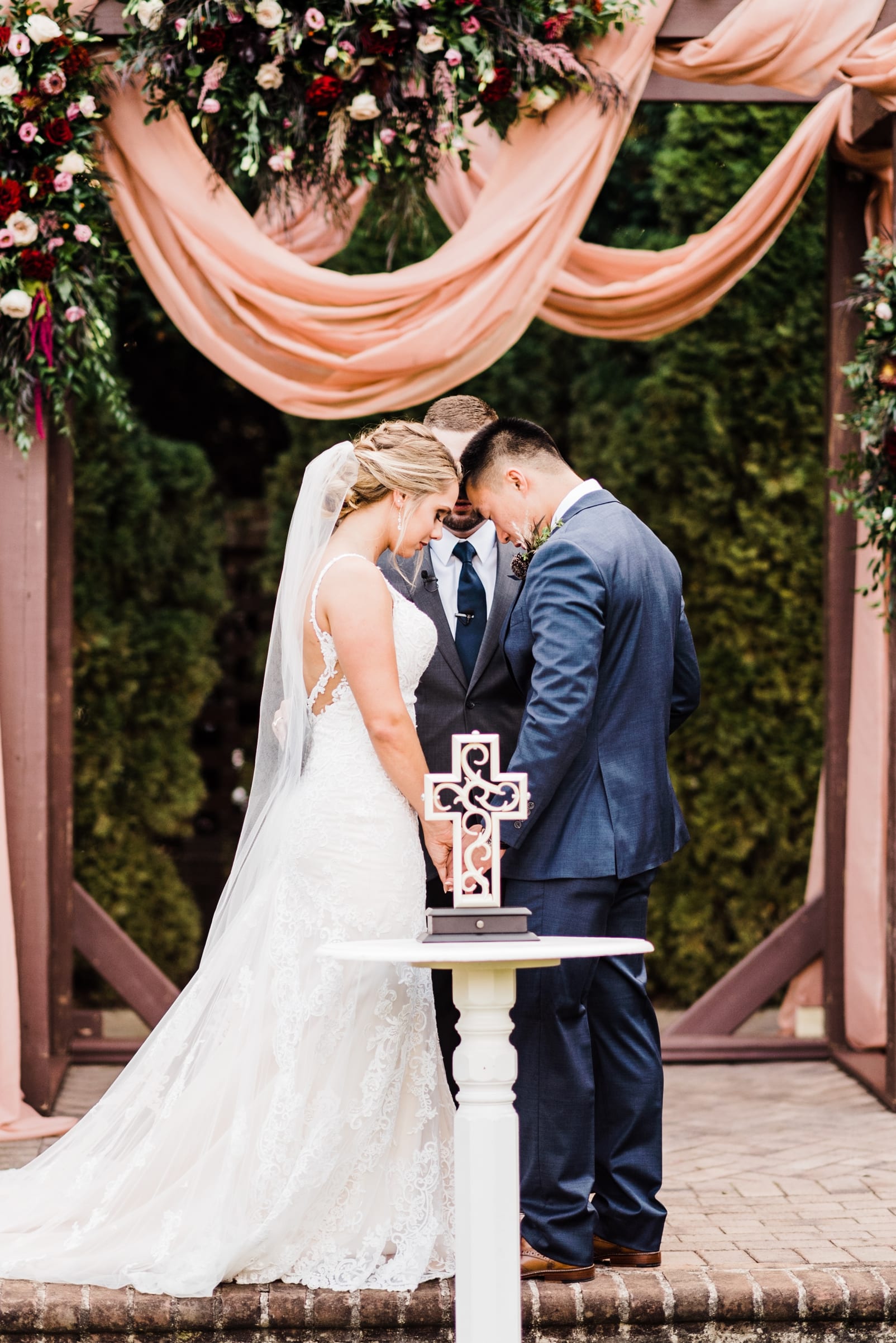 sutherland estate wedding photographer unity cross wedding ceremony site with florals arbor with fabric draping photo