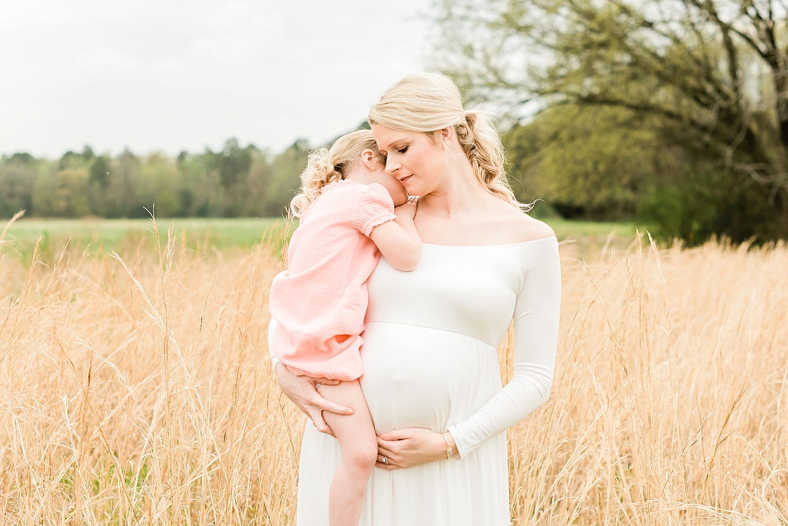 Wake Forest maternity mini session, 4 year old daughter laying her head on her mother's shoulder photo