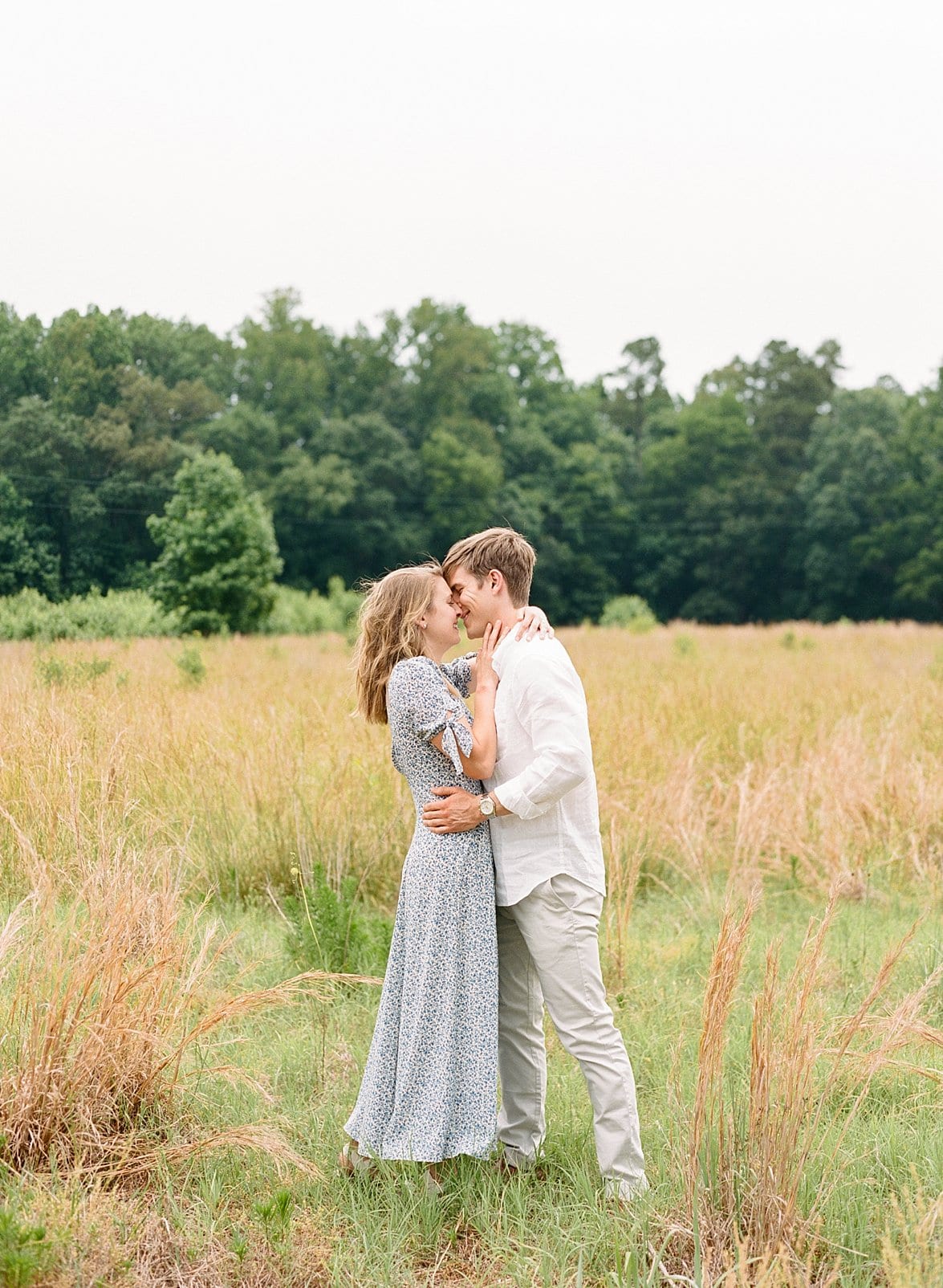 Raleigh couple kissing in the middle of a wheat field for engagement photos photo