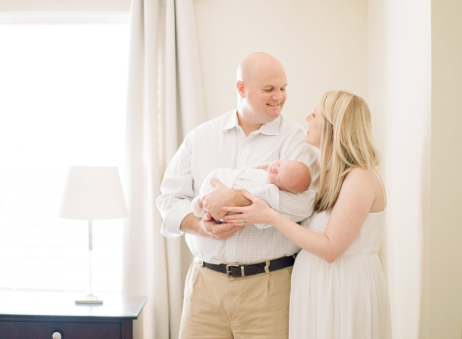 Raleigh father holding his newborn son and smiling at his wife photo