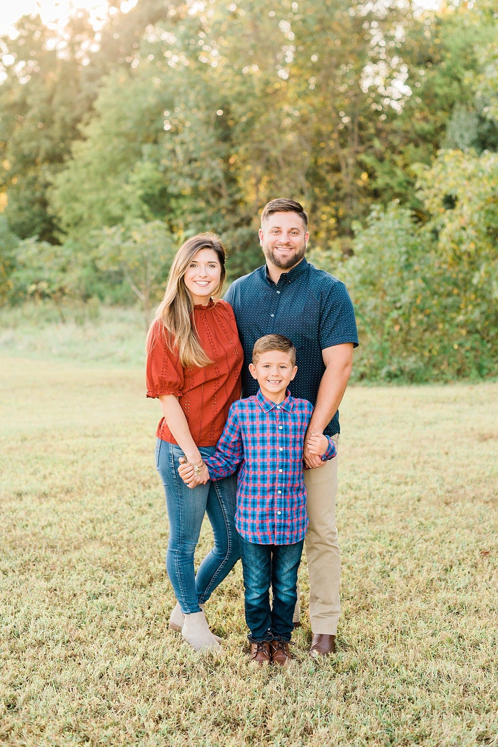 Raleigh family of three standing together in a field photo